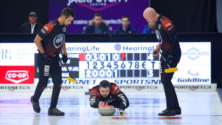 Matt Dunstone (centre) delivers a rock as Colton Lott (left) and Ryan Harnden (right) prepare to sweep during the fourth draw of the HearingLife Tour Challenge on Tuesday, Oct. 17, 2023, in Niagara Falls, Ont. (Anil Mungal/GSOC)