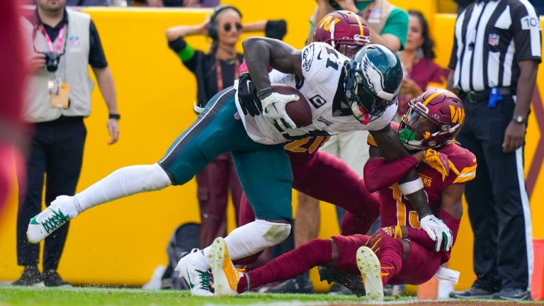 Philadelphia Eagles wide receiver A.J. Brown (11) scoring a touchdown against Washington Commanders safety Jartavius Martin (20) and cornerback Emmanuel Forbes (13) during the second half of an NFL football game, Sunday, Oct. 29, 2023, in Landover, Md. (Alex Brandon/AP)