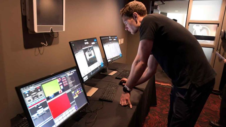 A technician sets up the latest advances in puck and player tracking at a tech showcase before an NHL hockey game. (Bill Kostroun/AP)