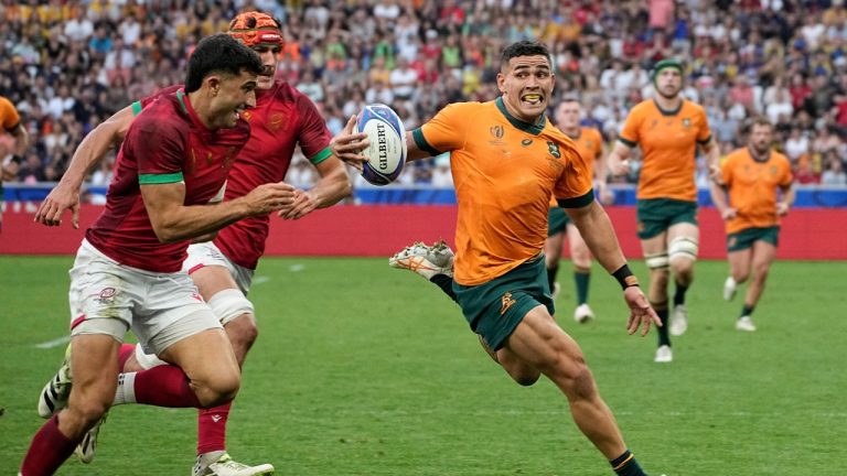 Australia's Izaia Perese, right, runs with the ball during the Rugby World Cup Pool C match between Australia and Portugal at the Stade Geoffroy Guichard in Saint-Etienne, France, Sunday, Oct. 1, 2023. (Laurent Cipriani/AP)