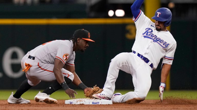 Texas Rangers' Marcus Semien, right, beats the tag by Baltimore Orioles shortstop Jorge Mateo (3) to reach second base on a throwing error to first base during the third inning of a baseball game in Arlington, Texas, Wednesday, April 5, 2023. (LM Otero/AP)