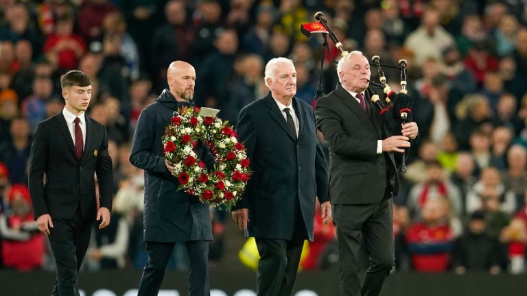 Manchester United's head coach Erik ten Hag, second left, with Alexander Stepney English former player, second right, and Manchester United academy player Dan Gore lays flowers in memory of Sir Bobby Charlton prior the Champions League group A soccer match between Manchester United and Copenhagen at the Old Trafford stadium in Manchester, England, Tuesday, Oct. 24, 2023. (Dave Thompson/AP)