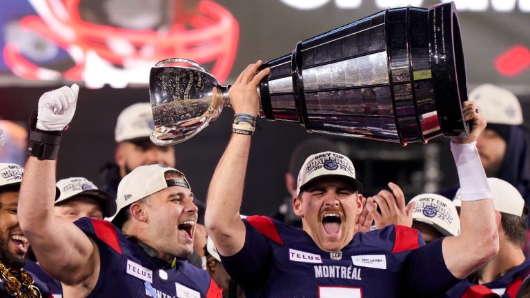 Montreal Alouettes quarterback Cody Fajardo (7) hoists the Grey Cup as fullback Alexandre Gagne (34) looks on as the Alouettes celebrate defeating the Winnipeg Blue Bombers in the 110th CFL Grey Cup in Hamilton, Ont., on Sunday, November 19, 2023. (Frank Gunn/CP)