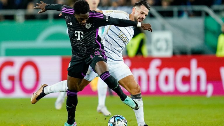 Bayern's Alphonso Davies, left, and Saarbruecken's Calogero Rizzuto battle for the ball during the German Soccer Cup second round soccer match between FC Saarbruecken and Bayern Munich at the Ludwigspark Stadium in Saarbruecken, Germany, Wednesday, Nov. 1, 2023. (Uwe Anspach/dpa via AP)