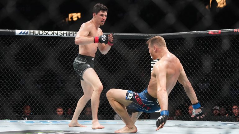 Mike Malott, back left, knocks down Adam Fugitt with a left hook during a UFC 289 welterweight bout, in Vancouver, on Saturday, June 10, 2023. THE CANADIAN PRESS/Darryl Dyck