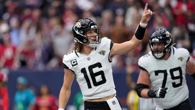 Jacksonville Jaguars quarterback Trevor Lawrence (16) and Luke Fortner (79) celebrate after Lawrence carried the ball for a touchdown in the first half of an NFL football game against the Jacksonville Jaguars in Houston, Sunday, Nov. 26, 2023. (Eric Gay/AP) 