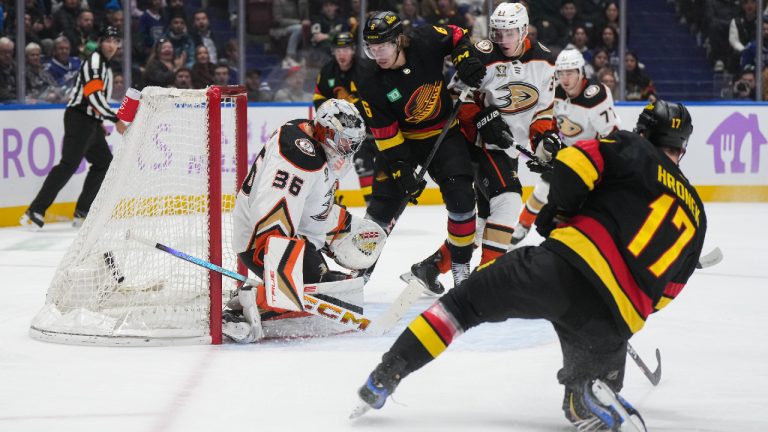 Vancouver Canucks' Brock Boeser, back centre, scores against Anaheim Ducks goalie John Gibson (36) as Pavel Mintyukov (34) watches during the first period of an NHL hockey game in Vancouver, on Tuesday, November 28, 2023. (Darryl Dyck/CP)