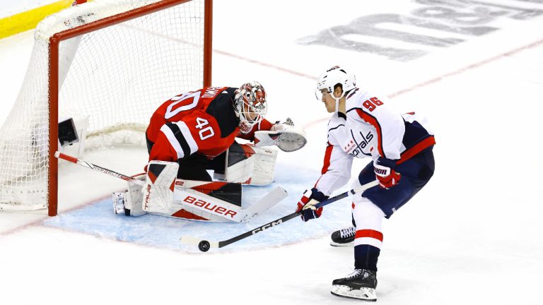 New Jersey Devils goaltender Akira Schmid (40) makes a save against Washington Capitals right wing Nicolas Aube-Kubel (96) during the third period of an NHL hockey game, Friday, Nov. 10, 2023, in Newark, N.J. (Noah K. Murray/AP)