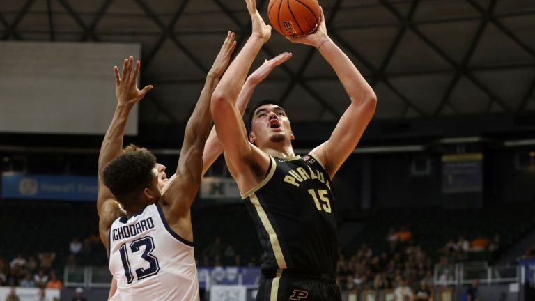 Marquette forward Oso Ighodaro and guard Tyler Kolek try to guard Purdue center Zach Edey during the first half of an NCAA college basketball game, Wednesday, Nov. 22, 2023, in Honolulu. (Marco Garcia/AP Photo)