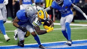 Green Bay Packers wide receiver Jayden Reed (11) catches a 10-yard reception for a touchdown and is tackled by Detroit Lions safety Brian Branch (32) during the first half of an NFL football game, Thursday, Nov. 23, 2023, in Detroit. (Duane Burleson/AP)