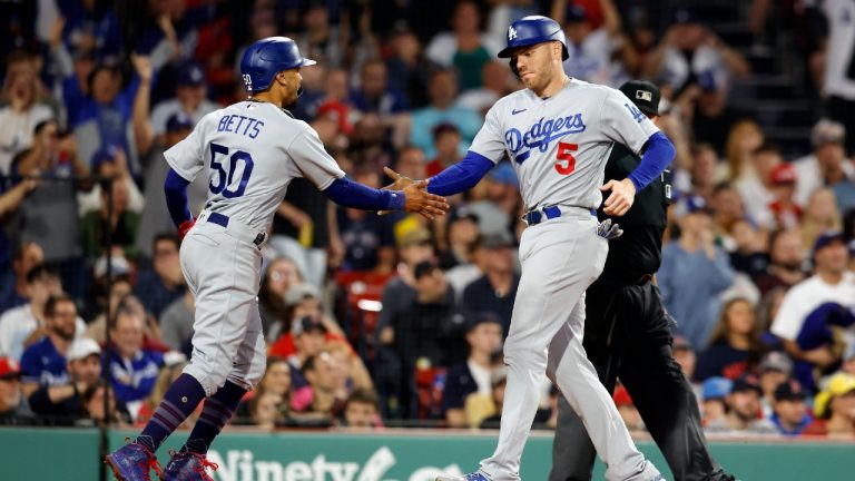 Los Angeles Dodgers' Mookie Betts (50) and Freddie Freeman (5) celebrate after scoring on a two-run double by Max Muncy against the Boston Red Sox during the seventh inning of a baseball game Friday, Aug. 25, 2023, in Boston. (Michael Dwyer/AP)