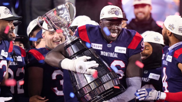 Montreal Alouettes defensive lineman Lwal Uguak (96) poses with the Grey Cup after the Alouettes defeated the Winnipeg Blue Bombers to win the 110th CFL Grey Cup in Hamilton, Ont., on Sunday, November 19, 2023. (Frank Gunn/CP)