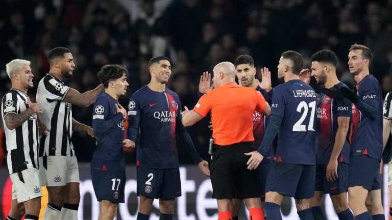 PSG players surrounded Referee Szymon Marciniak to appeal for a penalty during the Champions League group F soccer match between Paris Saint-Germain and Newcastle United on Tuesday. (AP/Christophe Ena)