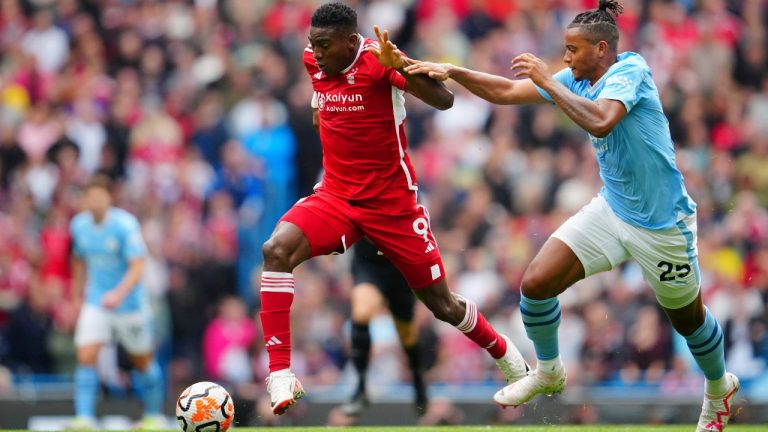 Nottingham Forest's Taiwo Awoniyi, left, fights for the ball with Manchester City's Manuel Akanji during the English Premier League soccer match between Manchester City and Nottingham Forest at Etihad stadium in Manchester, England, Saturday, Sept. 23, 2023. (Jon Super/AP Photo)