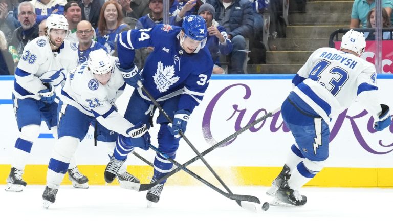 Toronto Maple Leafs centre Auston Matthews (34) battles Tampa Bay Lightning center Brayden Point (21) and Lightning defenceman Darren Raddysh (43) for control of the puck during second period NHL hockey action in Toronto on Monday November 6, 2023. (Chris Young/CP)