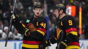 Vancouver Canucks' Elias Pettersson, left, listens to J.T. Miller before a faceoff during the third period of an NHL hockey game against the San Jose Sharks in Vancouver, on Monday, November 20, 2023. (Darryl Dyck/CP)