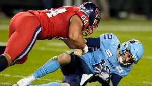 Montreal Alouettes defensive lineman Mustafa Johnson (94) tackles Toronto Argonauts quarterback Chad Kelly (12) on a run during second half CFL Eastern Division final football action. (Frank Gunn/THE CANADIAN PRESS)