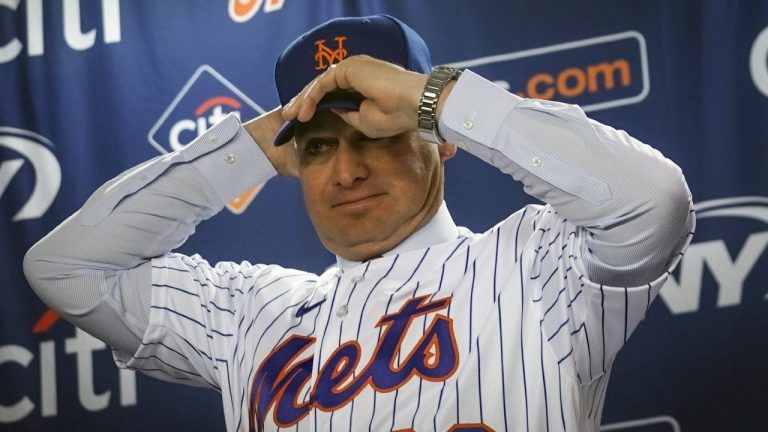 New York Mets new manager Carlos Mendoza puts on a team hat during an introductory baseball press conference at Citifield in New York, Tuesday, Nov. 14 2023. (Bebeto Matthews/AP)