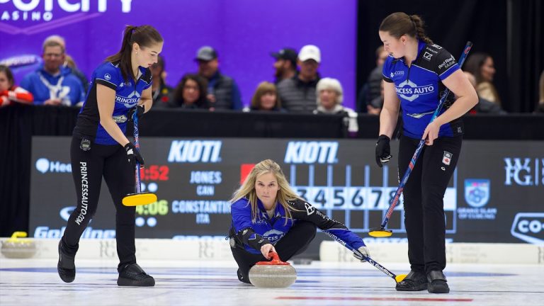 Jennifer Jones (centre) shoots a stone as Karlee Burgess (left) and Lauren Lenentine (right) prepare to sweep during the KIOTI National on Tuesday, Nov. 7, 2023, in Pictou County, N.S. (Anil Mungal/GSOC)