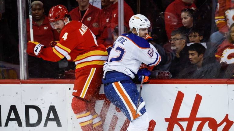 Edmonton Oilers forward Raphael Lavoie, right, checks Calgary Flames defenceman Rasmus Andersson during third period NHL preseason hockey action in Calgary, Alta., Friday, Sept. 29, 2023. (Jeff McIntosh/THE CANADIAN PRESS)