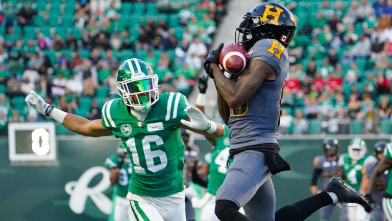 Hamilton Tiger-Cats receiver Omar Bayless (80) catches the football as Saskatchewan Roughriders defensive back Amari Henderson (16) defends during the first half of CFL football action at Mosaic Stadium in Regina, on Saturday, October 7, 2023. (Heywood Yu/CP)