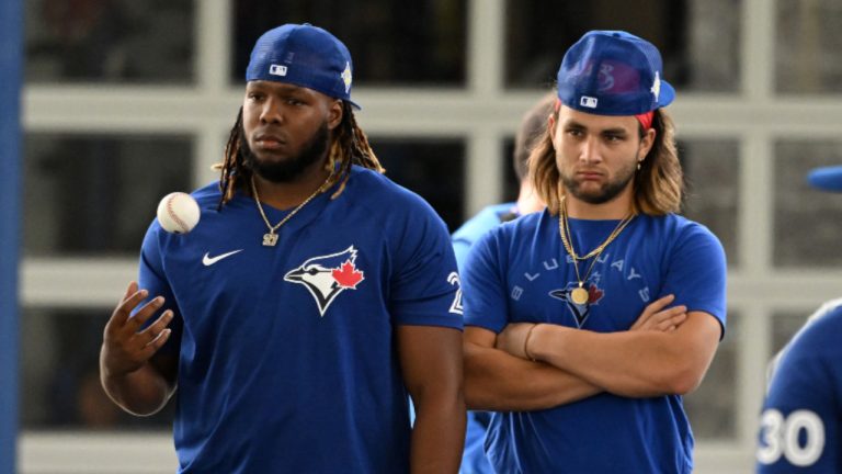 Toronto Blue Jays' Vladimir Guerrero Jr., left, and Bo Bichette listen to a coach speak during a spring training workout, in Dunedin, Fla., Wednesday, March 16, 2022. (Steve Nesius/CP)