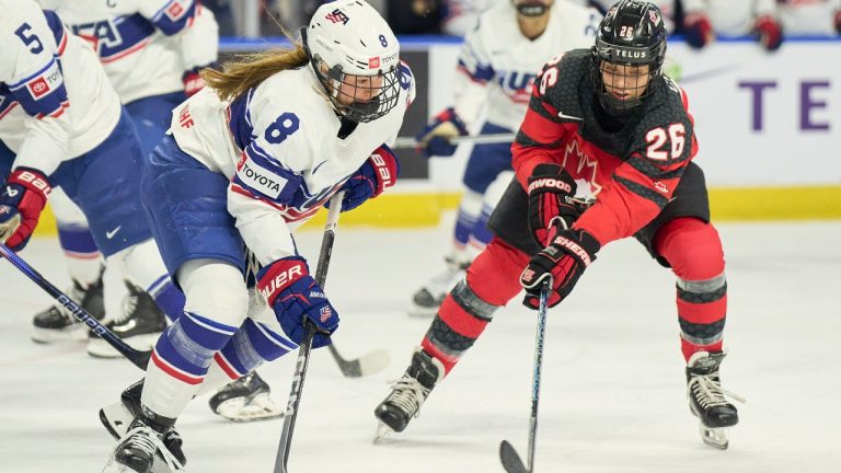 Team USA's Haley Winn, left, and Canada's Emily Clark fight for control of the puck during the Canada USA Rivalry series in Kitchener, Ontario on Thursday, December 14, 2023. (Geoff Robins/CP)