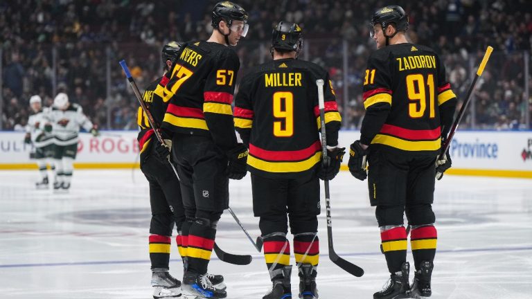 Vancouver Canucks' Tyler Myers (57) and Nikita Zadorov (91) listen to J.T. Miller (9) during the third period of an NHL hockey game against the Minnesota Wild in Vancouver, on Thursday, December 7, 2023. (Darryl Dyck/CP)