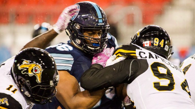 Toronto Argonauts offensive lineman Isiah Cage (66) is stopped by Hamilton Tiger-Cats defensive end Justin Capicciotti (94) during second half CFL football action in Toronto on Friday, Oct. 12, 2018. THE CANADIAN PRESS/Christopher Katsarov