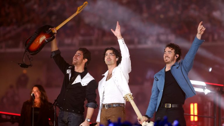 From left to right, Nick Jonas, Joe Jonas and Kevin Jonas, of the Jonas Brothers, perform during halftime of an NFL football game between the New York Giants and Dallas Cowboys Thursday, Nov. 24, 2022, in Arlington, Texas. (AP Photo/Michael Ainsworth)