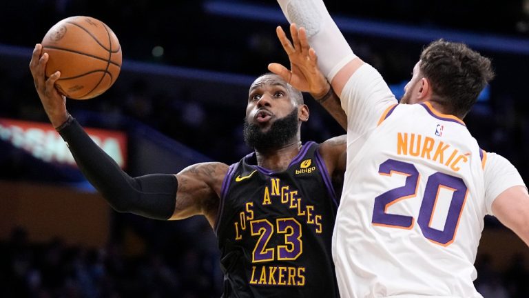 Los Angeles Lakers forward LeBron James, left, shoots as Phoenix Suns center Jusuf Nurkic defends during the first half of an NBA basketball In-Season Tournament quarterfinal game Tuesday, Dec. 5, 2023, in Los Angeles. (Mark J. Terrill/AP)