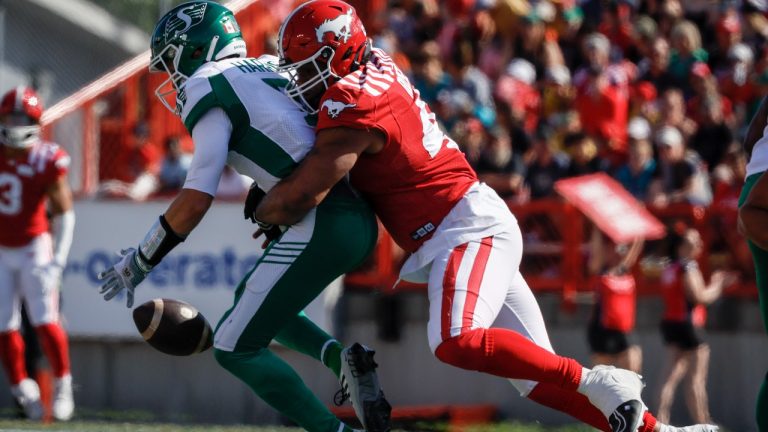 Saskatchewan Roughriders quarterback Trevor Harris, left, drops the ball as Calgary Stampeders defensive linemen Mike Rose sacks him during first half CFL football action in Calgary, Alta., Saturday, June 24, 2023. (Jeff McIntosh/CP)