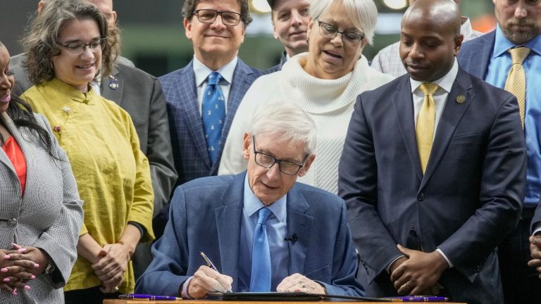 Wisconsin Gov. Tony Evers signs Assembly Bill 438 and Assembly Bill 439 at American Family Field Tuesday, Dec. 5, 2023, in Milwaukee. The bills use public funds to help the Milwaukee Brewers repair their stadium over the next three decades. (Morry Gash/AP Photo)