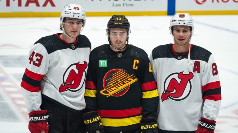 New Jersey Devils' Luke Hughes, left, along with his brothers, Vancouver Canucks' Quinn Hughes and Devils' Jack Hughes pose for a photo before their NHL hockey game in Vancouver on Tuesday, Dec. 5, 2023. (Ethan Cairns/CP)