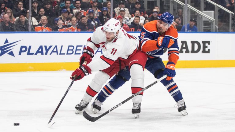 Carolina Hurricanes' Jordan Staal (11) and Edmonton Oilers' Cody Ceci (5) battle for the puck during first period NHL action in Edmonton on Wednesday, December 6, 2023. (Jason Franson/CP)