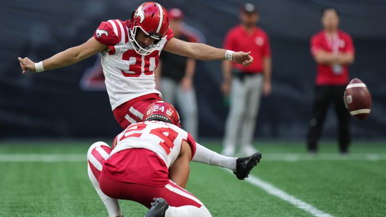 Calgary Stampeders' Rene Paredes (30) kicks his first of three successful field goals as Cody Grace (24) holds during the first half of a CFL football game against the B.C. Lions, in Vancouver, on Saturday, August 12, 2023. (Darryl Dyck/CP)