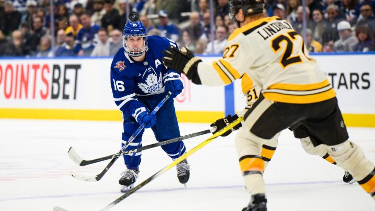 Toronto Maple Leafs right wing Mitchell Marner (16) passes the puck past Boston Bruins centre Matthew Poitras (51) and defenceman Hampus Lindholm (27) during first period NHL hockey action in Toronto on Saturday, Dec. 2, 2023. (Christopher Katsarov/CP)