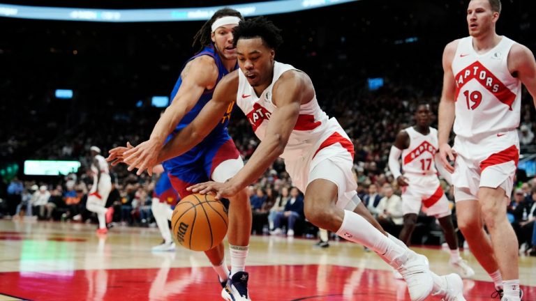 Toronto Raptors' Scottie Barnes (4) battles for a loose ball with Denver Nuggets' Aaron Gordon (50) during second half NBA basketball action in Toronto on Wednesday, December 20, 2023. (Frank Gunn/CP)