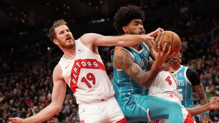 Charlotte Hornets centre Nick Richards (4) and Toronto Raptors centre Jakob Poeltl (19) vie for control of the ball during first half NBA basketball action in Toronto, Monday, Dec. 18, 2023. (Nathan Denette/CP)