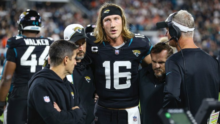 Jacksonville Jaguars quarterback Trevor Lawrence (16) is helped from the bench area to a stadium tunnel during the fourth quarter an NFL football game against the Cincinnati Bengals, Monday, Dec. 4, 2023, in Jacksonville, Fla. (Gary McCullough/AP)