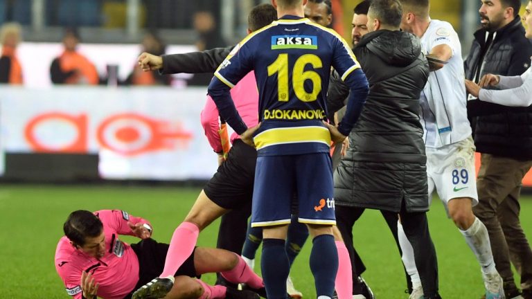 Referee Halil Umut Meler, left, falls down after being punched by MKE Ankaragucu president Faruk Koca, barely seen second left, at the end of the Turkish Super Lig soccer match between MKE Ankaragucu and Caykur Rizespor in Ankara, Monday, Dec. 11, 2023. (Abdurrahman Antakyali/Depo Photos via AP)