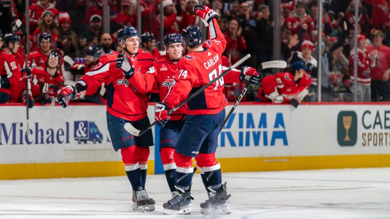 Washington Capitals centre Hendrix Lapierre (29) celebrates with defenceman Martin Fehervary (42) and defenseman John Carlson (74) after Lapierre scored against the New York Islanders during the first period of an NHL hockey game Wednesday, Dec. 20, 2023, in Washington. (Stephanie Scarbrough/AP)