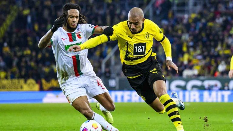 Dortmund's Donyell Malen, right, and Augsburg's Kevin Mbabu in action during the Bundesliga soccer match between FC Augsburg and Borussia Dortmund at WWK-Arena. (Tom Weller/AP)