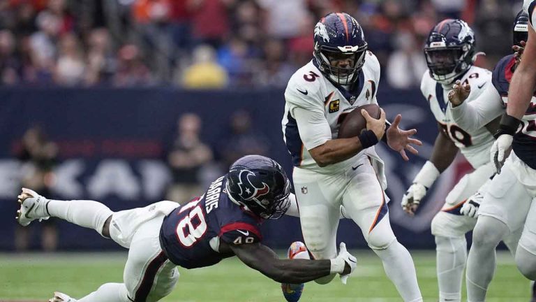 Denver Broncos quarterback Russell Wilson (3) tries to get past Houston Texans linebacker Christian Harris (48) in the first half of an NFL football game. (Eric Gay/AP)