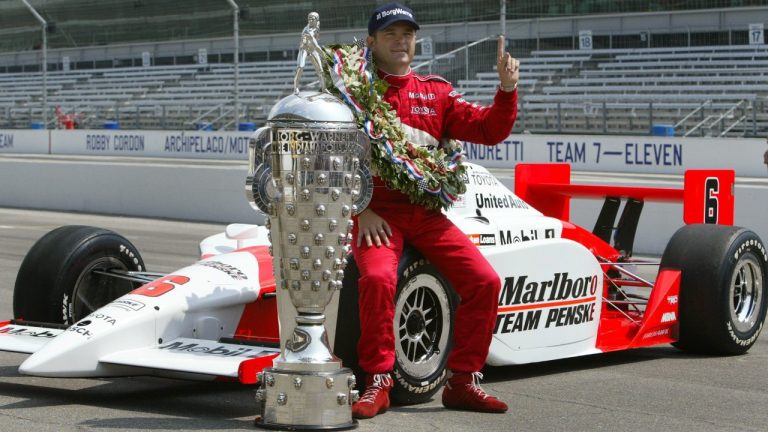 Indy 500 champion Gil de Ferran of Brazil poses on his winning car with Borg-Warner Trophy during the traditional winners photo session at the Indianapolis Motor Speedway Monday, May 26, 2003. (AP)