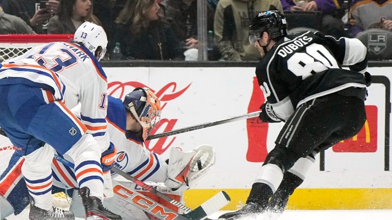 Edmonton Oilers goaltender Stuart Skinner, center, makes a glove save on a shot by Los Angeles Kings center Pierre-Luc Dubois, right, as center Mattias Janmark defends during the first period of an NHL hockey game Saturday, Dec. 30, 2023, in Los Angeles. (Mark J. Terrill/AP)