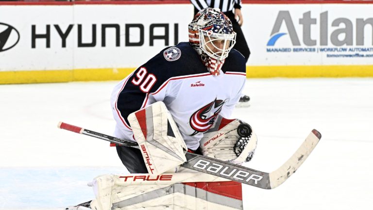 Columbus Blue Jackets goaltender Elvis Merzlikins (90) gloves the puck during the second period of an NHL hockey game against the New Jersey Devils, Friday, Nov. 24, 2023, in Newark, N.J. (Bill Kostroun/AP)