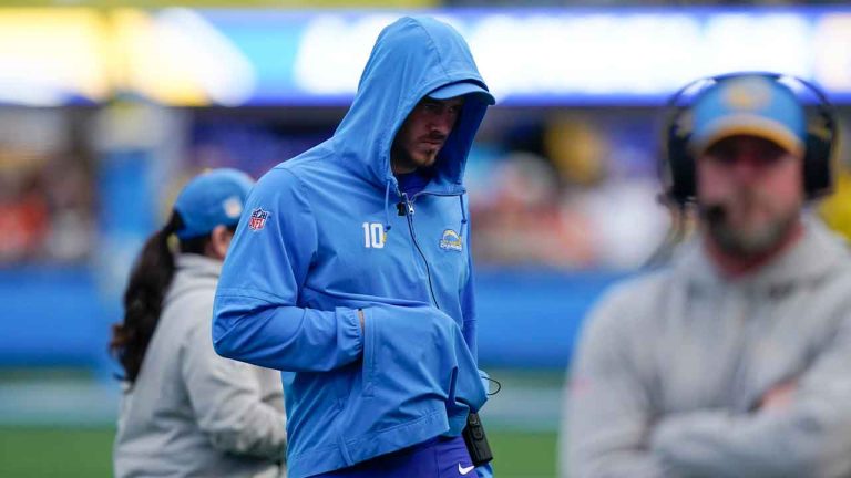 Los Angeles Chargers quarterback Justin Herbert walks on the sidelines after an injury with his hand in his hoodie pocket during the second half of an NFL football game against the Denver Broncos. (Ryan Sun/AP)