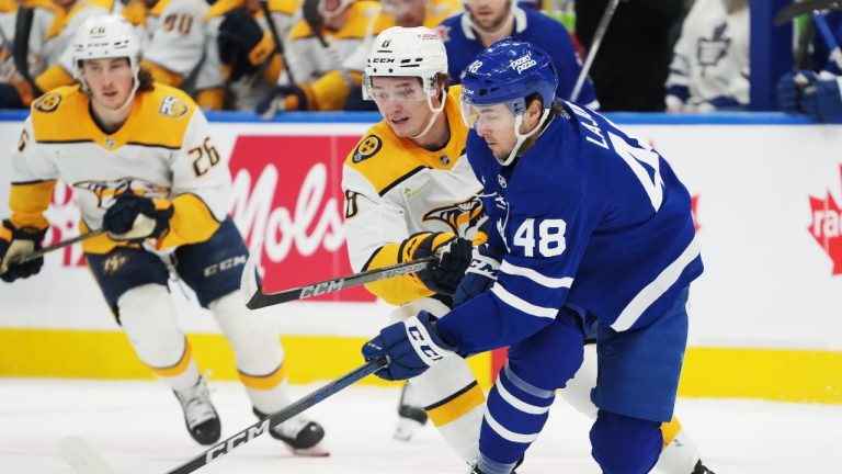 Nashville Predators forward Cody Glass (8) and Toronto Maple Leafs defenceman Maxime Lajoie (48) battle for the puck during first period NHL hockey action in Toronto on Saturday, December 9, 2023. (Nathan Denette/THE CANADIAN PRESS)