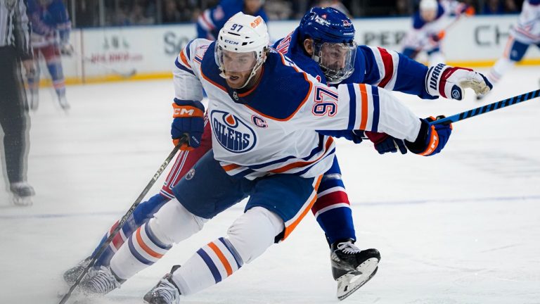 Edmonton Oilers centre Connor McDavid (97) fends off New York Rangers cetre Barclay Goodrow during the first period of an NHL hockey game in New York, Friday, Dec. 22, 2023. (Peter K. Afriyie/AP)